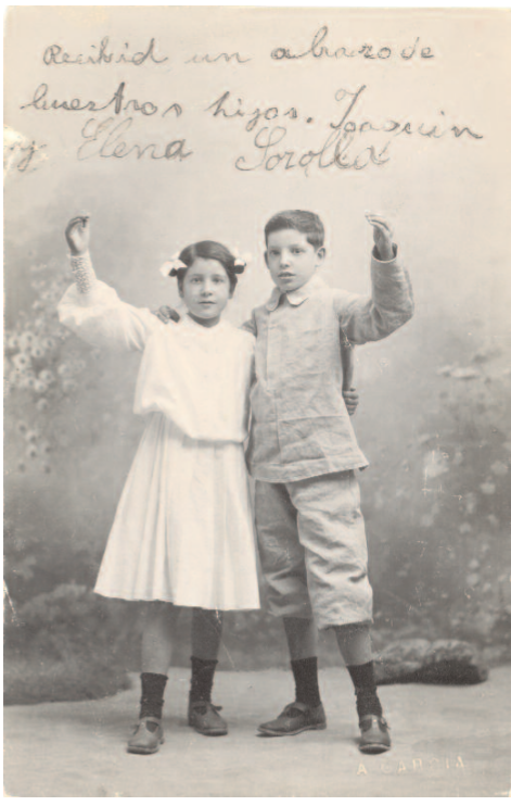 # 98.- García Peris, Antonio Joaquín y Elena Sorolla García, 1905 (ca.) Gelatina DOP. 137 x 87 mm. Positivo antiguo Tarjeta postal Recibid un abrazo de / vuestros hijos. Joaquín / y Elena Sorolla a tinta negra (margen superior del anverso del positivo); A. GARCÍA sello seco (ángulo inferior derecho del anverso del positivo); A Don Joaquín Sorolla / 2ª Avenue de Friedland / (Francia) / París a tinta negra (reverso del positivo); 23 JUN 05 impreso en negro (matasello en el reverso del positivo) N.º Inv. 80246 Retrato de estudio de Elena y Joaquín dedicado a sus padres. Exposiciones: 2007, Valencia –”Antonio García. Cómo se forma una imagen”– (sin n.º cat.)Foto extraida del catálago: LA COLECCIÓN DE FOTOGRAFÍA ANTIGUA DEL MUSEO SOROLLA